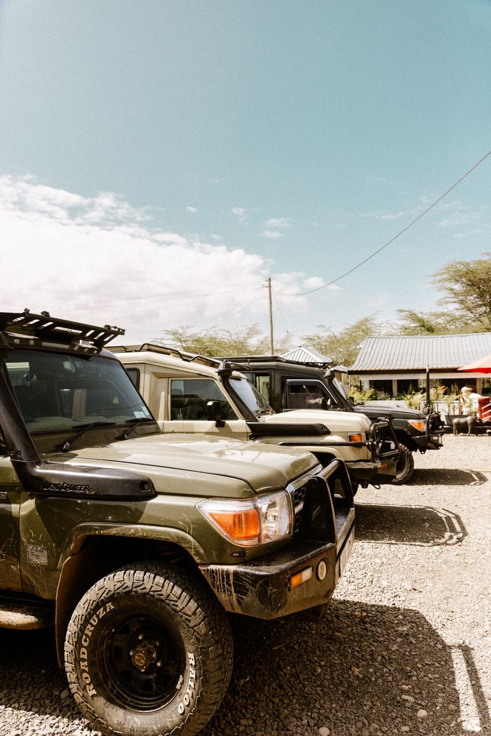 Mastering the First Impression: Your intriguing post title goes here Row of parked safari vehicles under a clear blue sky, ready for adventure.